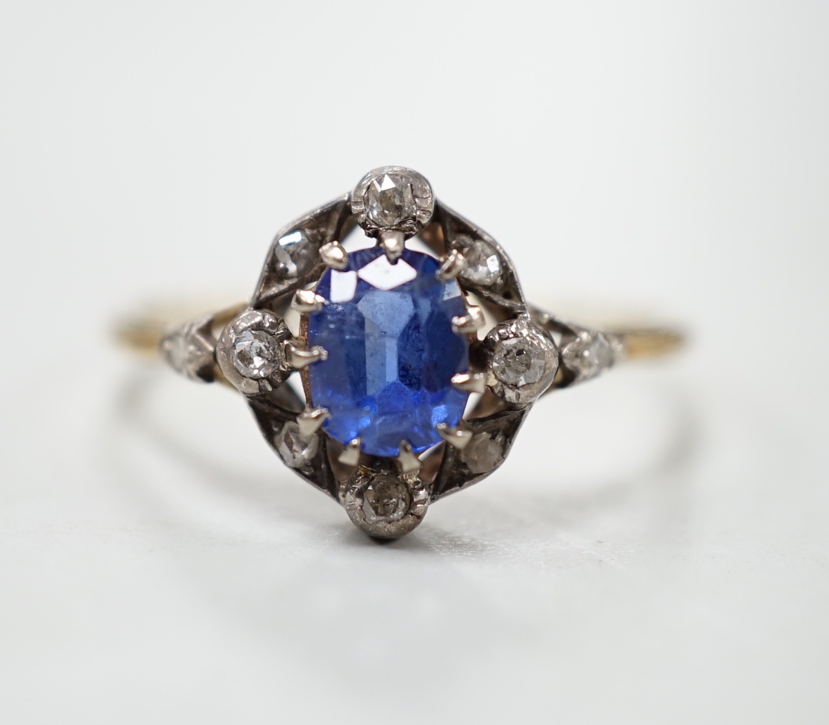 An early 20th century yellow metal, sapphire and diamond cluster set oval cluster ring, size R/S, gross weight 2.1 grams.